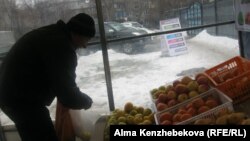 Покупатель Владимир Кузнецов в торговой палатке. Алматы, 7 марта 2014 года.