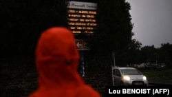 Пешак го чита предупредувањето за црвен аларм во Франција.