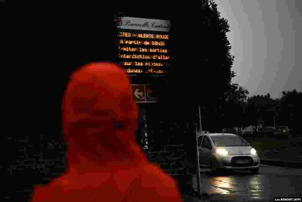 Një kalimtar shikon paralajmërimin ku shkruan: "Alarm i kuq: nga ora 18:00 e tutje kufizoni daljet dhe shmangni plazhet" në veriperëndim të Francës më 8 janar 2026. 