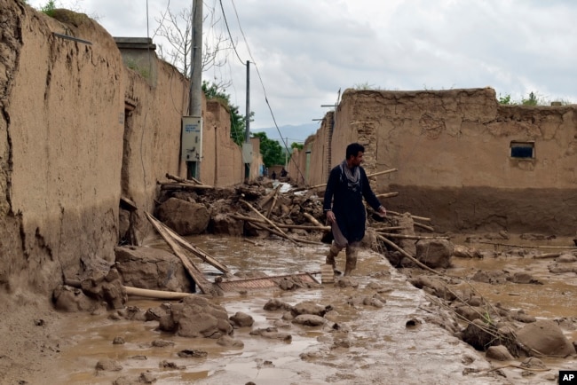 Një burrë ec pranë shtëpisë së vet të dëmtuar nga vërshimet në provincën Baghlan në veri të Afganistanit, 11 maj 2024.