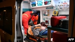 Ukrainian rescuers help an injured man after a drone strike on a residential area in Kharkiv late on May 2.