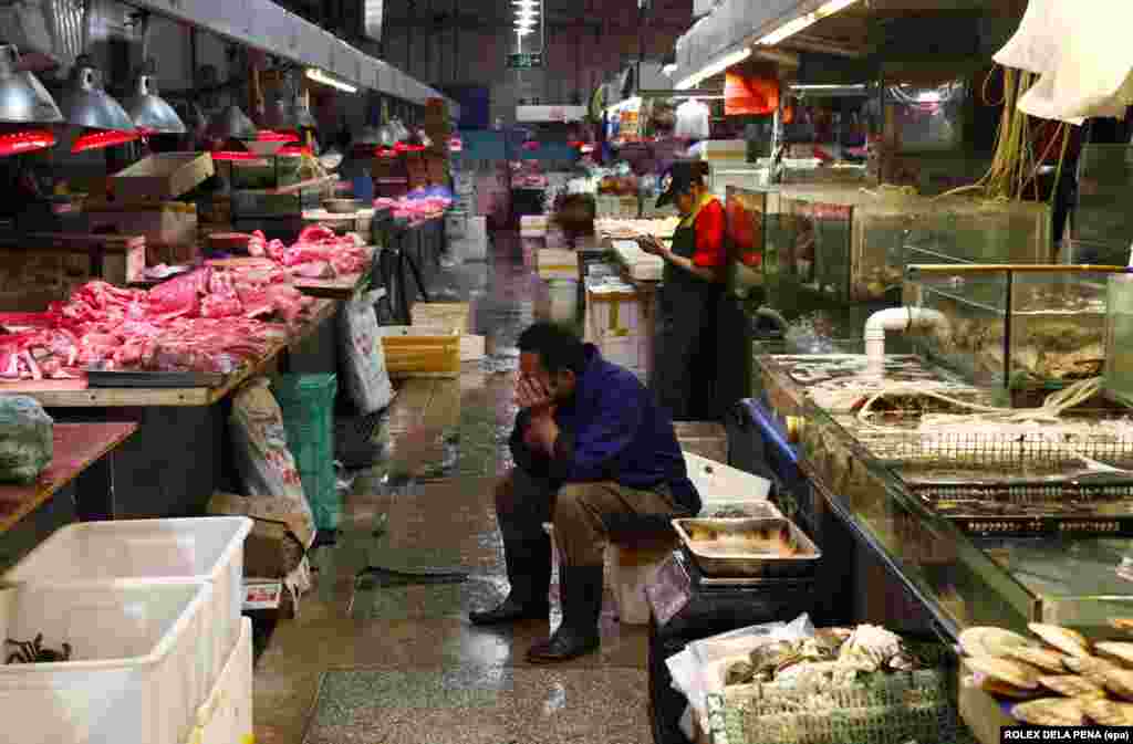 &quot;Wet markets,&quot; like this one in Beijing, sell fresh produce such as fish, meat, and vegetables. They are named largely for the water used to hose down the stalls at the end of each day, often leaving the floors so wet that vendors work in rubber boots. &nbsp;