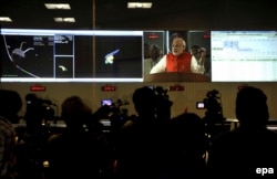 Премьер-министр Индии Нарендра Моди поздравляет коллектив Индийской организации по исследованию космоса с успешной доставкой летательного аппарата на Марс. 24 сентября 2014 года.