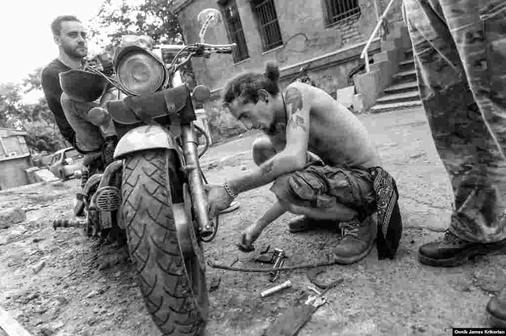 A member of the Cross Riders MC repairing one of their bikes. Locals didn&rsquo;t object to the bikers locating their clubhouse in their neighborhood, but they did mind the noise of the motorcycles. The Cross Riders will move to a new location at the end of the month.