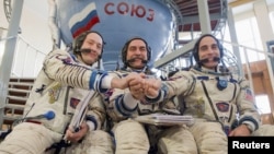 Russian cosmonauts Pavel Vinogradov (center) and Aleksandr Misurkin (left) pose with U.S. astronaut Christopher Cassidy for a photograph before taking an exam at the cosmonaut training center in Star City, outside Moscow, in early March.