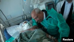 Иемен денсаулық сақтау министрі Ахмад әл-Анси "Әл-Қаида" шабуылынан жараланған офицердің жанында отыр. Сана, 6 желтоқсан 2013 жыл.