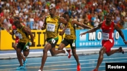 Usain Bolt of Jamaica (C) crosses the finish line next to American Justin Gatlin, winning the 100 meter race in a competition before Rio.