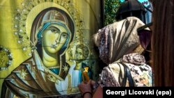 A Macedonian Orthodox believer lights candles outside the St. Mother of God church in Skopje, Macedonia, in August 2017.