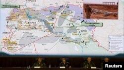 Russian Defense Ministry officials sit under a display showing the Turkish-Syrian border during a briefing in Moscow on December 2 regarding its accusations of Ankara's involvement in the illegal IS oil trade.