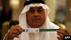 A Saudi official displays an electronic identification bracelet that Saudi authorities are giving to pilgrims ahead of the hajj.