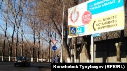 Полицейские рядом с билбордом, призывающим к борьбе с коррупцией. Алматы, 21 марта 2015 года.