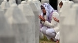 Women pray as they visit the graves of relatives at the memorial cemetery in the village of Potocari, near the town of Srebrenica in eastern Bosnia, on July 9, 2025.