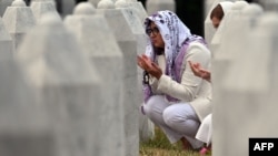 Women pray as they visit the graves of relatives at the memorial cemetery in the village of Potocari, near the town of Srebrenica in eastern Bosnia, on July 9, 2025.