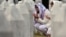 Women pray as they visit the graves of relatives at the memorial cemetery in the village of Potocari, near the town of Srebrenica in eastern Bosnia, on July 9, 2025.