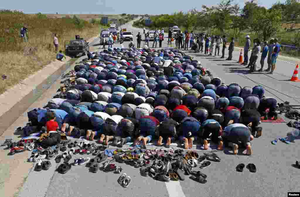 Migrants pray on a highway near Edirne, Turkey. (Reuters/Osman Orsal)