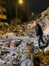 Мужчина обыскивает разрушенные здания в Диярбакыре, Турция