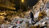Мужчина обыскивает разрушенные здания в Диярбакыре, Турция