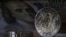 KAZAKHSTAN -- Kazakh 200 tenge coins are pictured in front of a U.S. dollar banknote - generic