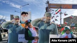 Iranian children carry a cardboard cutout of slain Iranian General Qasem Soleimani, on the 40th day of his killing in a US drone strike, during commemorations marking 41 years since the Islamic Revolution, in Tehran, February 11, 2020