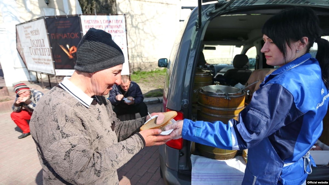 Співробітники українського благодійного фонду «Соціальне партнерство» роздають обіди безхатченкам у Києві