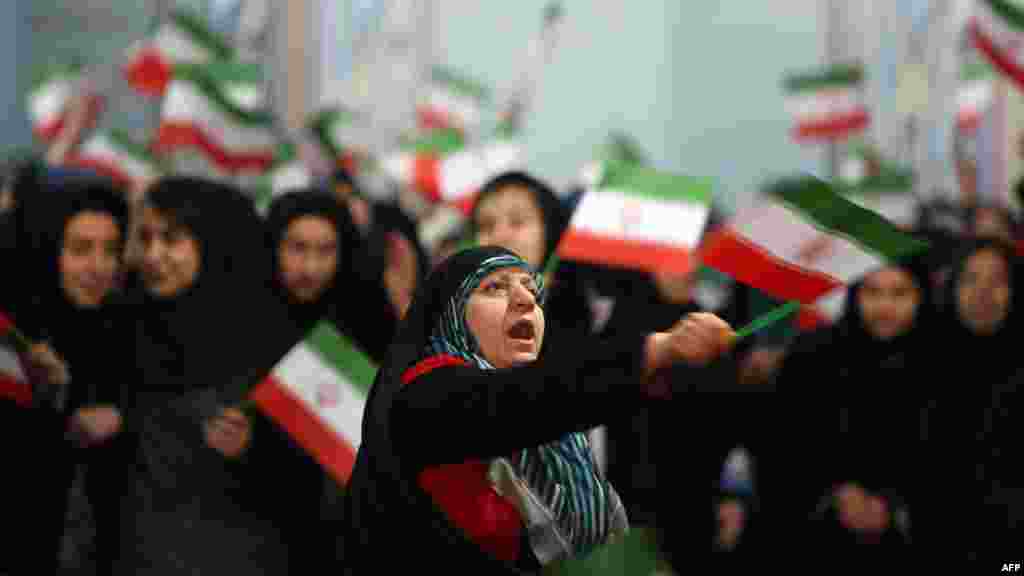 Women wave Iranian flags during a ceremony marking the 33rd anniversary of Ayatollah Ruhollah Khomeini&#39;s return from exile at Khomeini&#39;s mausoleum in Tehran. (AFP/Atta Kenare)