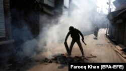 An Indian policeman puts out a bonfire at a road block in Srinagar on October 29.