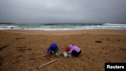 Femei curățind plaja Vilar, la Ribeira, în nord-vestul Spaniei, luni, 8 ianuarie. (Foto: REUTERS/Miguel Vidal) 