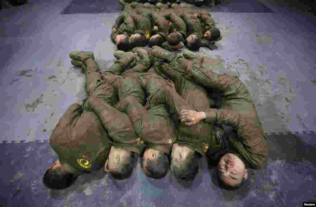 Cadets hold each other for warmth as they sleep during a break from high intensity training at the Tianjiao Special Guard/Security Consultant camp on the outskirts of Beijing, China. (Reuters/Jason Lee)