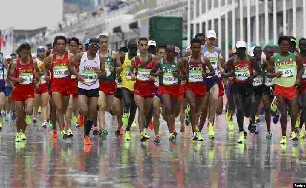 Athletes run in the men&#39;s marathon. Eliud Kipchoge of Kenya won gold.