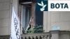 Një zyrtar pranë flamurit të Emiratit Islamik të Afganistanit në ballkonin e Ambasadës afgane në Moskë, 4 korrik.