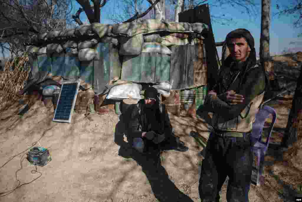 A rebel fighter of the Jaish al-Islam (Islam Army) recharges his equipment with a solar panel near the front line at Tal Farzat in the rebel-controlled eastern Ghouta area of Damascus, Syria. (epa/Mohammed Badra)