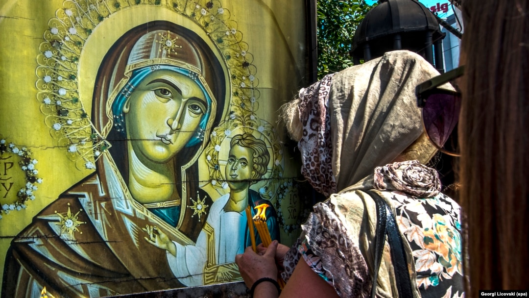 A Macedonian Orthodox believer lights candles outside the St. Mother of God church in Skopje, Macedonia, in August 2017.