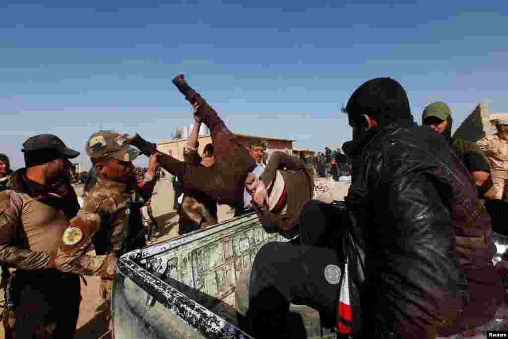 Iraqi soldiers dump a suspected Islamic State fighter into a pickup truck on February 26.&nbsp;An Iraqi Army commander told Reuters that, unlike Iraqi-born militants fighting with Islamic State, foreign jihadis have no chance of escaping the city undetected and &quot;will therefore fight to the end.&quot;