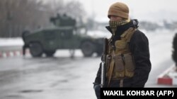 An Afghan security personnel guards the site of an attack near the Marshal Fahim Military Academy base in Kabul on January 29. 