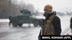 An Afghan security personnel guards the site of an attack near the Marshal Fahim Military Academy base in Kabul on January 29.