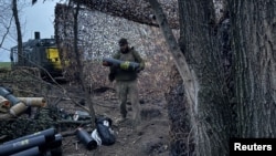 Артилеристи 147-ї десантно-штурмової бригади розвантажують  патрони для гаубиці поблизу прифронтового міста Покровськ у Донецькій області, 30 березня 2026 року