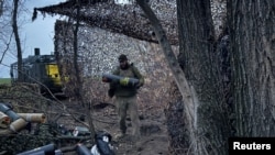 Артилеристи 147-ї десантно-штурмової бригади розвантажують патрони для гаубиці поблизу Покровська в Донецькій області, 30 березня 2026 року