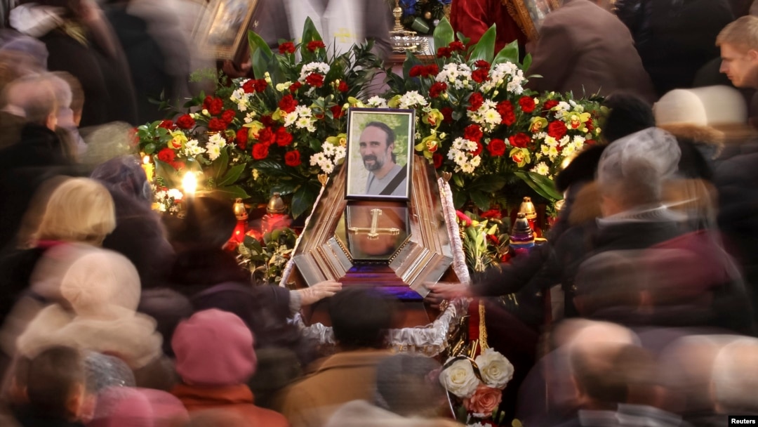 People walk around the coffin of Yuriy Verbytskyy, an antigovernment activist, at his funeral in Lviv on January 24.