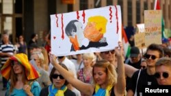Зображення поцілунку президента США Дональда Трампа та президента Росії Володимира Путіна на плакаті активістів під час протесту у Гельсінкі, 15 липня 2018 року 
