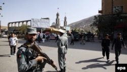 Afghan security forces secure the surrounding near the site of a bomb blast that targeted a Shi'ite mosque, in Kabul on October 9.