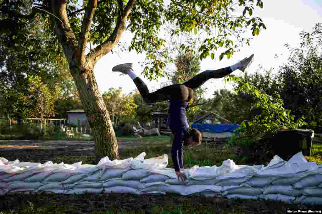 A young horse vaulter practices on the sandbags in a small family-run stable amid flooding in Szodliget, Hungary.