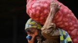 <p>A laborer carries a sack of potatoes at a wholesale vegetable market in Islamabad, Pakistan. 