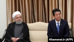 Japanese Prime Minister Shinzo Abe sits next to Iranian President Hassan Rohani (L) during a meeting with the supreme leader in Tehran, June 13, 2019