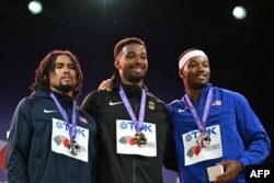 Лео Нойгебауер позира на почетната стълбичка след титлата си в десетобоя на Световното първенсво по лека атлетика в Токио, заедно със сребърния медалист Ейдън Оуенс-Делерме (вляво) и Кайл Гарланд, заел третото място, 21 септмври 2025 г.