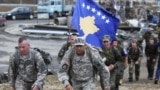 Kosovo -- Two US soldiers walk in front of a Kosovo national flag being carried by Kosovo Security Force (KSF) members during a march close to the town of Vushtri, October 17, 2015