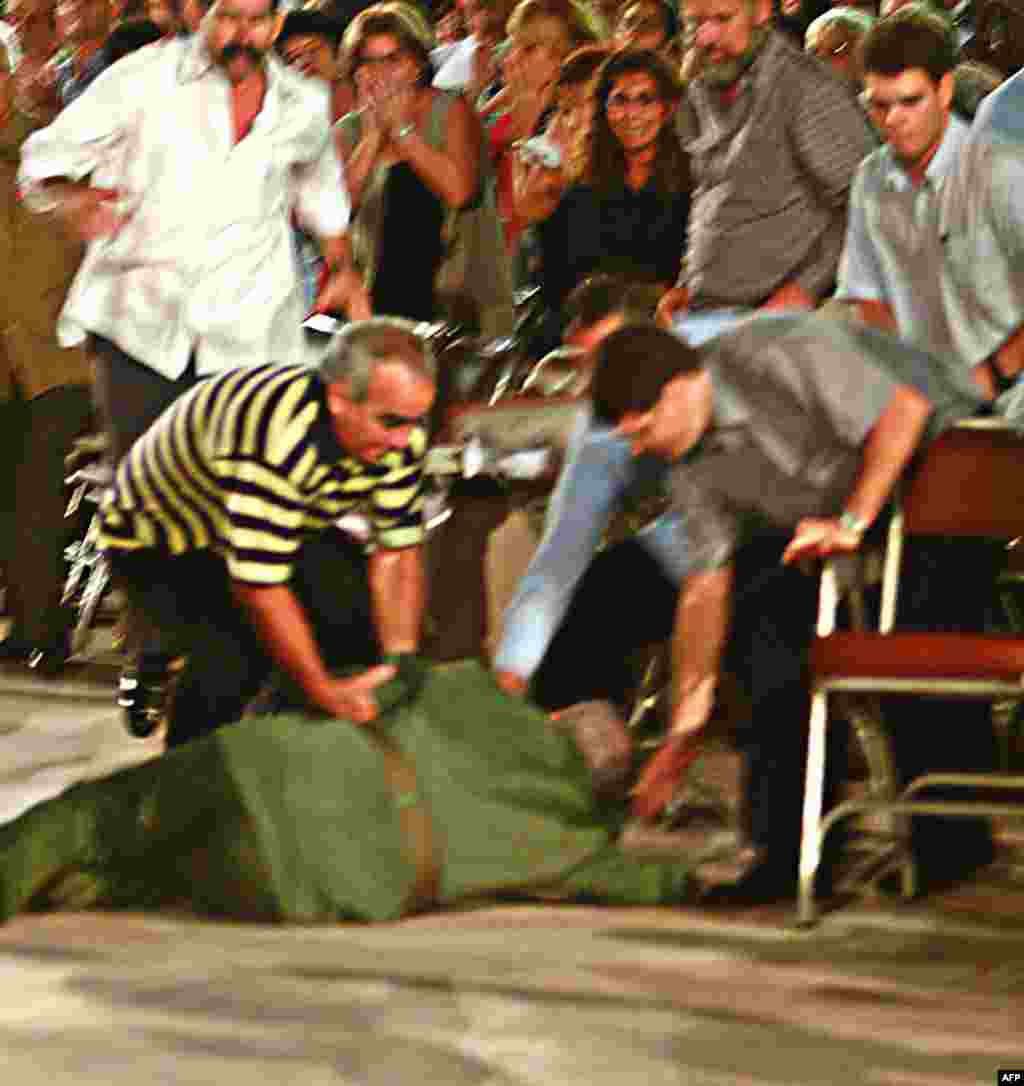 Castro (center) is helped by his bodyguards after he fell over at the end of a speech following a graduation ceremony in central Cuba in October 2004.