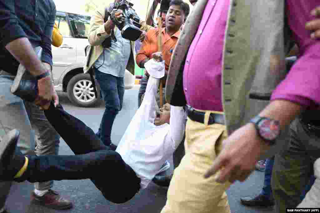 Civil rights activist, Shamshad Pathan (Center) shouts as Gujarat Police officials detain him during a protest outside Indian Institute of Management in Ahmedabad on December 16.