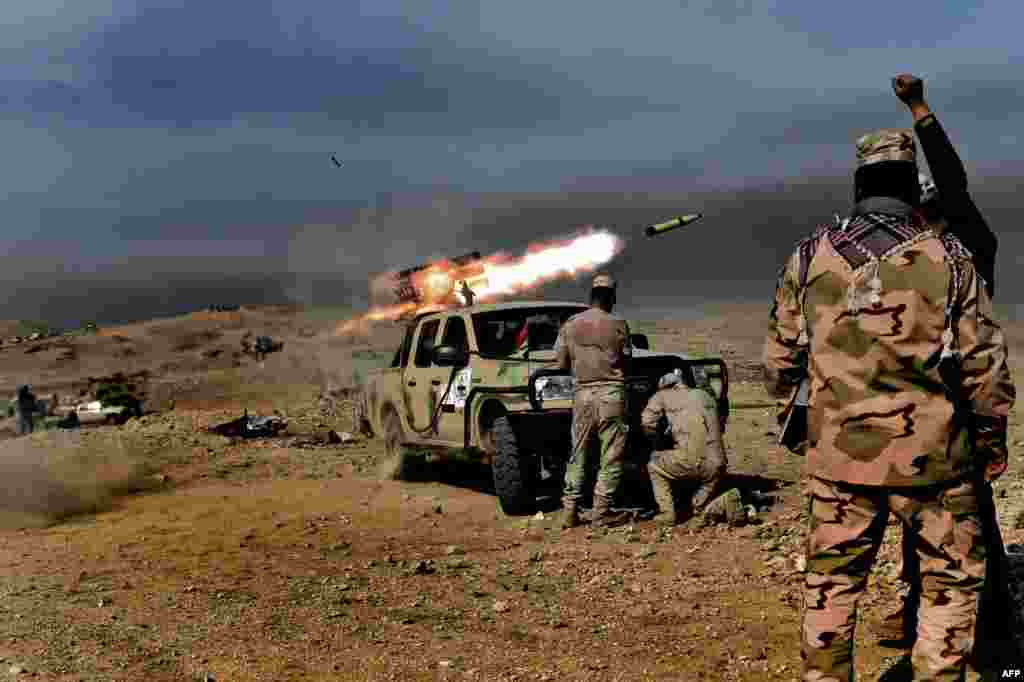 Iraqi troops fire a multiple-rocket launcher from a hill on the southwestern outskirts of Mosul on February 27.
