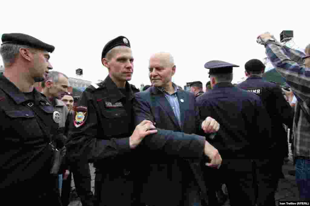 Mikhail Shneider of the Solidarity movement is led away by police.