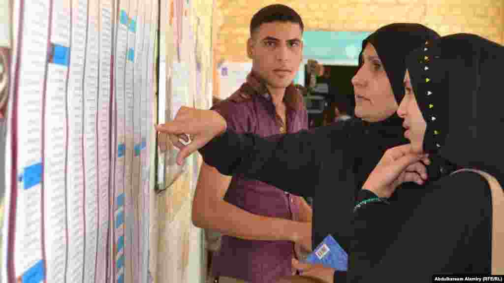 Women voters look for their names on voters' lists in Basra.